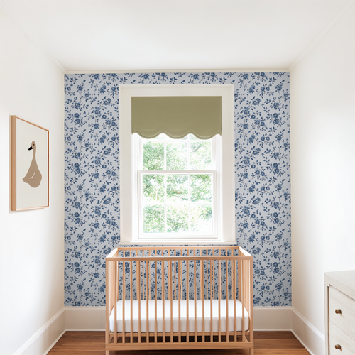 Nursery room with floral wallpaper, wooden crib, and window.