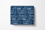 Folded blue blanket with 'JAMES' text pattern on a white background